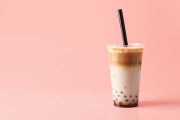 Tasty milk bubble tea in plastic cup on pink background, space for text