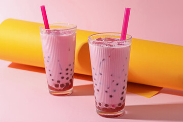 Tasty milk bubble tea in glasses on color background