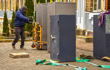 Moving heavy safes on a pallet jack during daylight hours in an urban setting