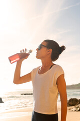 woman drinking an energy from a bottle on a hot day