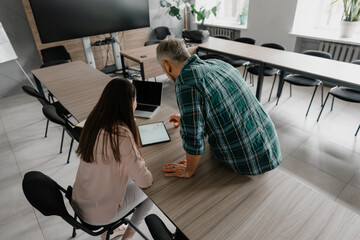Colleagues discussing their project using a tablet in a professional workspace