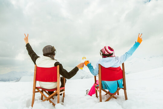 Couple relax sit on chairs in snowy ski resort with beer bottle, concept of leisure, winter holiday, relaxation, carefree lifestyle, freedom, cozy outdoor relaxation moment