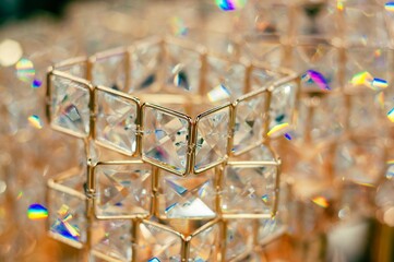 A detailed view of a beautiful crystal object, sparkling with light and gold accents.