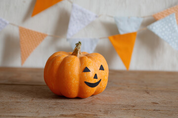 Cheerful pumpkin with bunting on wooden table