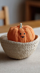 Cute pumpkin with smiley face in woven bowl on table