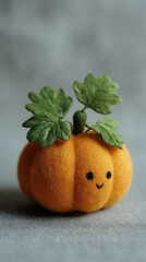 Cute felt pumpkin with embroidered leaves and smiling face