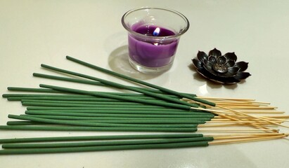 purple candle lighted with flame with incense