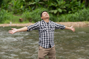  Man meditating with a feeling of river, nature and peace.