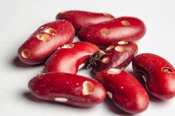 A close-up shows damaged kidney beans with holes, suggesting insect infestation or poor storage.