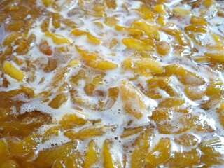 Apricot slices in sugar syrup. Food background. Making homemade apricot jam