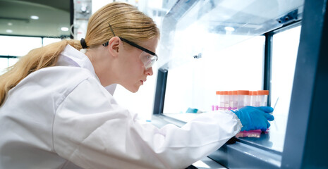 Female specialist medical laboratory scientist working with lab instrument for analyze diagnostic...