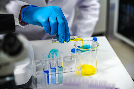 Unknown scientist working with chemical testing tube in laboratory