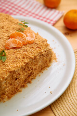 Delicious honey cake with tangerine garnish and crumb topping on white plate