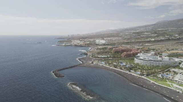 Drone flies north along coast toward Playa El Beril beach in Costa Adeje, Tenerife, Canary Islands, Spain