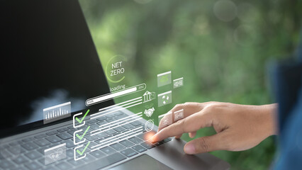 A businessman hand using a laptop with Net Zero and carbon neutrality icons, symbolizing sustainability, environmental goals, green technology, and climate action strategy.