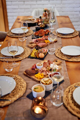 Elegant dining table with assorted charcuterie platters and wine glasses