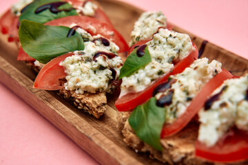 Delicious tomato basil bruschetta with creamy ricotta and balsamic drizzle on wooden platter