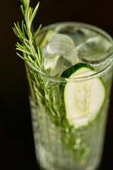 Refreshing cucumber rosemary cocktail with ice cubes in a glass