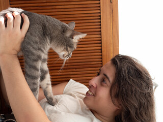 Femme blanche souriante tenant son chat allong&eacute; avec regard complice