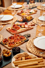 Elegant dining spread with bruschetta and antipasto on rustic wooden table setting