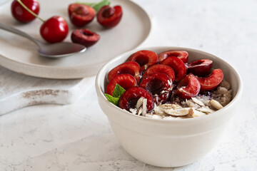 Buckwheat porridge with fresh sweet cherries, berry jam, and almonds. Vegan breakfast bowl