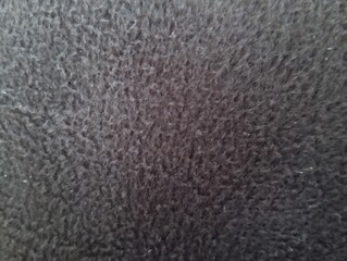 Fototapeta premium Close-up shot showcasing a textured, dark, and fluffy fabric surface.