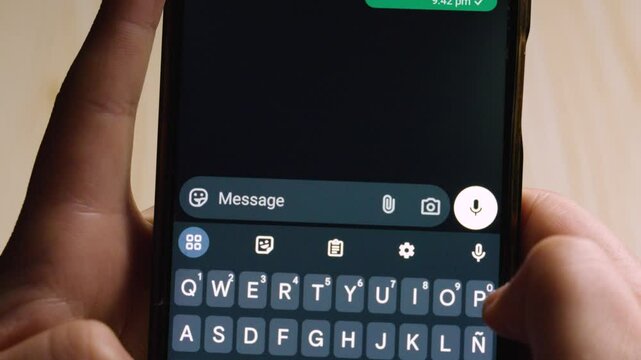 Close-up of hands using a smartphone to send an urgent text message reading &ldquo;ASAP!!!&rdquo; in a dark-mode messaging app.