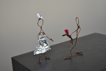 Handcrafted wire man giving flowers to wire woman. Kids crafts made from reused copper wire and...