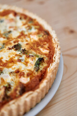 Savory broccoli and cheese quiche on wooden table