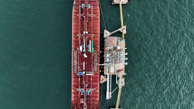 Aerial view oil ship tanker vessel loading and unloading in oil terminal station refinery, Global business import export logistic transport sea freight cargo tanker, Red crude oil tanker ship at port.