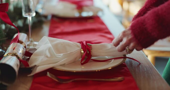 Christmas, setting and hands of woman by table for lunch celebration, holiday party and event. December, dining room and person with napkin, ribbon and plate for tradition, festive season and xmas