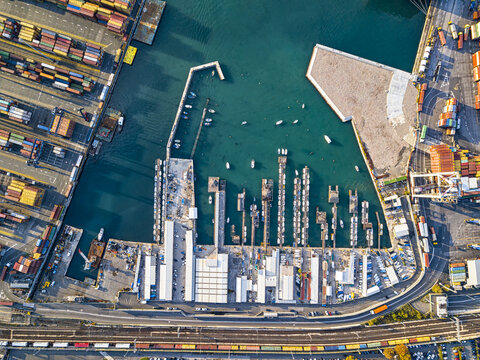 Aerial view of cargo ships docked at the port, where colorful containers meet the deep blue sea, creating a striking contrast, La Spezia, Liguria, Italy.