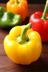Ripe colorful bell peppers on wooden table, closeup