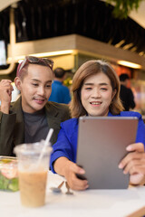 Gender diverse coworker business team eating salad and working digitally