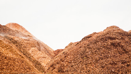 mountains of wood chips against a grey sky