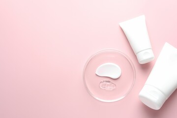 Different cosmetic products in Petri dish and tubes on pink background, flat lay. Space for text