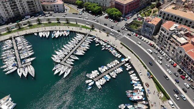 Sorvolo aereo con drone porto turistico darsena con vista barche a vela al tramonto della cala di palermo che evidenziano inquinamento in un paesaggio mozzafiato dello skyline della citt&agrave; antica 