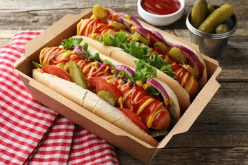 Tasty hot dogs served on wooden table, above view