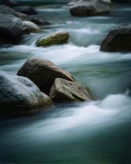 Long exposure blurred photography of river current flowing over rocks nature environment tranquil scene