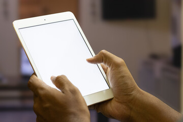 Man holding tablet or smart device with white screen in the home office