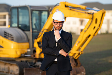 Construction business owner. Man in suit and hardhat halmet at building construction site. Civil...