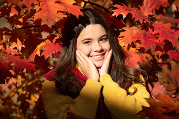 Autumn teen child portrait. happy child standing at beautiful autumn leaves. fall season