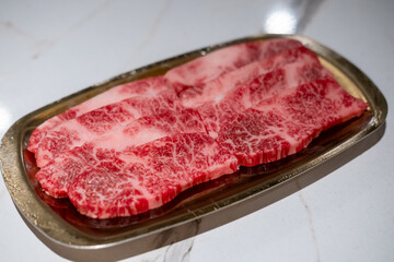 Raw Sliced Hanwoo Beef, marbled Korean Style Meat prepared on the golden plate