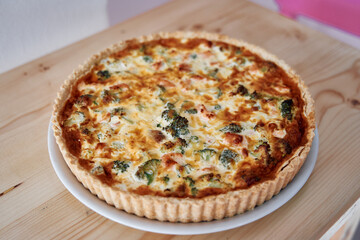 Delicious broccoli and cheese quiche on wooden table