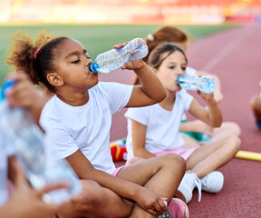 Children running on track at the stadium, practice during sports class in school training , little...