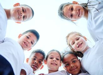 Group portrait of children team forming huddle, view from below. Sport, unity, togetherness,...