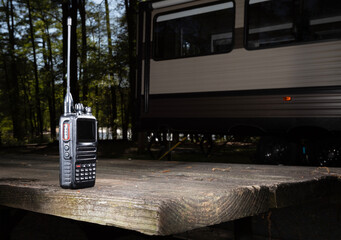 Walkie talkie on a table with a camper trailer behind