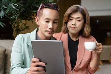 Transgender and non-binary coworkers working remotely in cafe