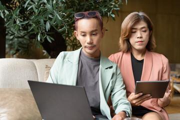 Transgender and non-binary coworkers working remotely in cafe