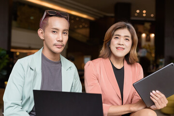 Transgender and non-binary coworkers working remotely in cafe